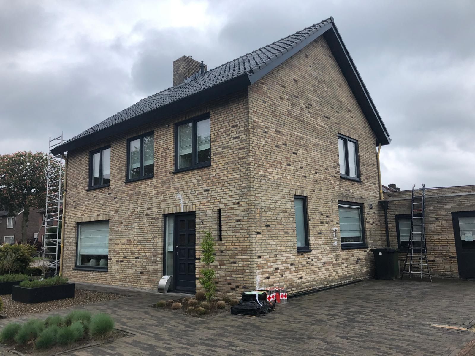 Woonhuis in Helmond met gemeleerde baksteengevel en donkere kozijnen, voor de schilderbeurt